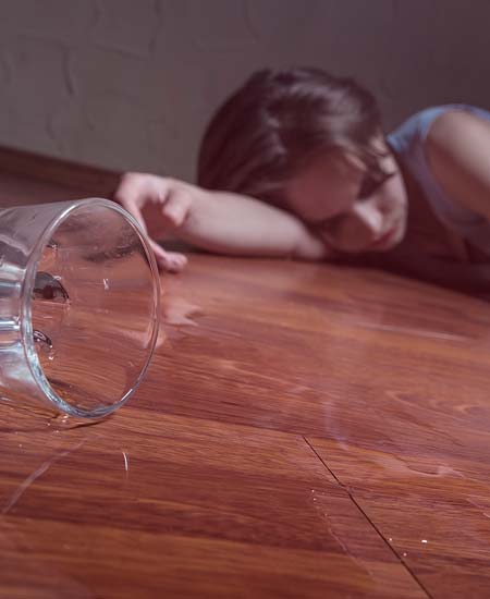 девушка лежит на полу рядом со стаканом